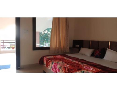 a bedroom with a bed with a large window at Mridul Homestay Orchha, Madhya Pradesh in Orchha