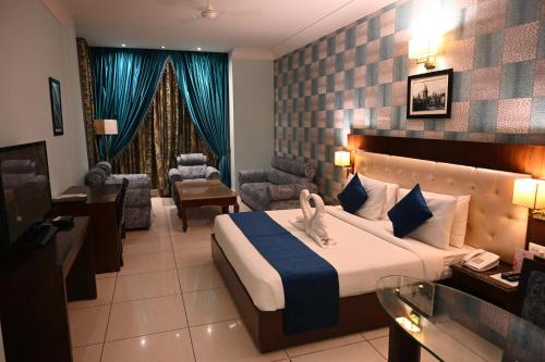 a hotel room with a bed and a living room at Deventure Hotel, Karnal in Karnal