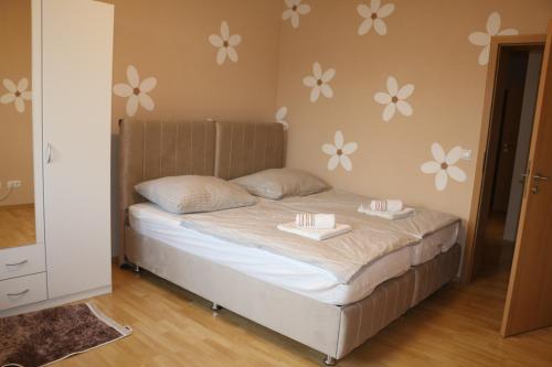 a bed in a room with flowers on the wall at Vienna's Cozy Corner - charming familiy apartment in Gerasdorf bei Wien