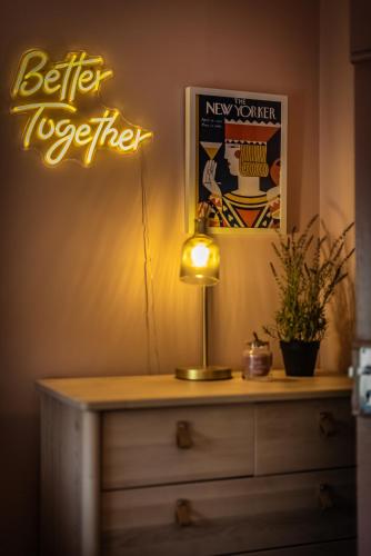 a light on a dresser in a room with a sign at City Escape Waterford City Sleeps 6 in Waterford
