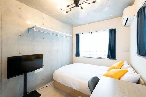 a bedroom with a bed and a flat screen tv at Ferio Kamata II in Tokyo