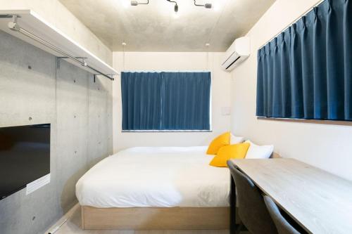 a small bedroom with a bed with yellow pillows at Ferio Kamata II in Tokyo
