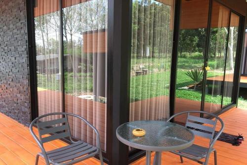 eine Terrasse mit einem Tisch und 2 Stühlen auf einer Veranda in der Unterkunft Forest Hill Resort in Chanthaburi