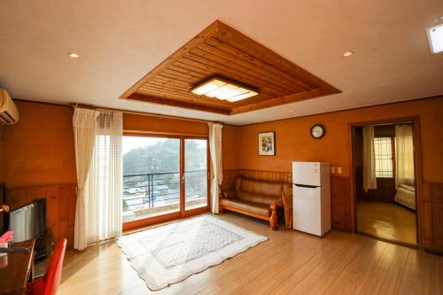 a living room with a couch and a refrigerator at Jisakke Poongyeong Jeju in Seogwipo