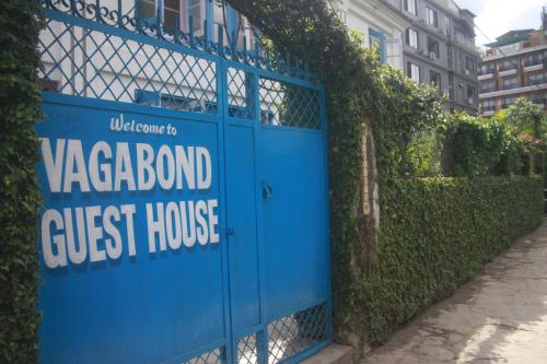 a blue gate with a sign that reads vaz board guest house at Vagabond Guest House in Pokhara