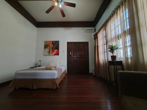 a bedroom with a bed and a ceiling fan at Hotel Casa Colon in San José