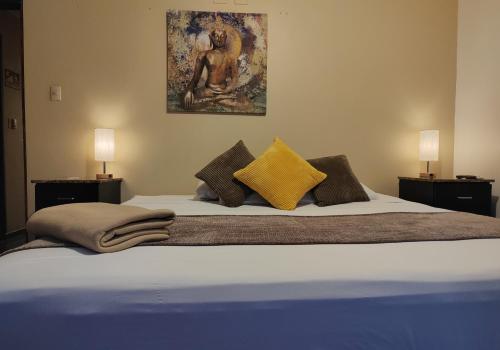 a bedroom with a large bed with two lamps at Hotel Casa Colon in San José