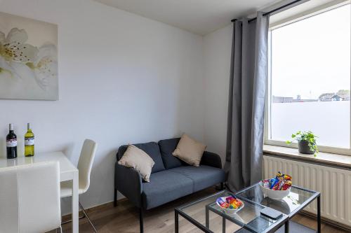 ein Wohnzimmer mit einem Sofa und einem Tisch in der Unterkunft Sunny Studio - Only 5-Min Walk to Sea & Dunes in Wijk aan Zee
