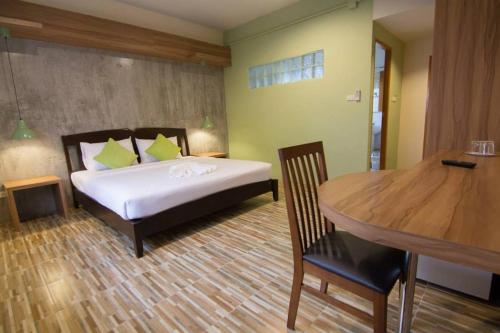 a bedroom with a bed and a table in a room at K.L. Boutique Hotel in Krabi