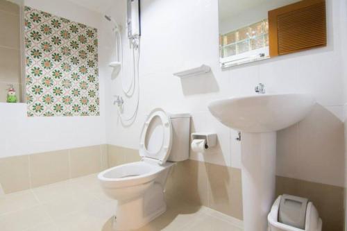 a bathroom with a white toilet and a sink at K.L. Boutique Hotel in Krabi
