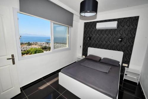 een kleine slaapkamer met een bed en een raam bij Wohnung mit Meerblick in Bodrum City