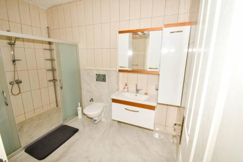 een badkamer met een toilet, een wastafel en een douche bij Wohnung mit Meerblick in Bodrum City