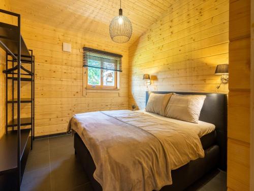 1 dormitorio con 1 cama en una cabaña de madera en Cozy holiday home in Limburg with a beautiful view en Schinnen
