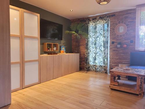 a living room with a table and a large window at Charmante maisonnette proche plage in Fréjus