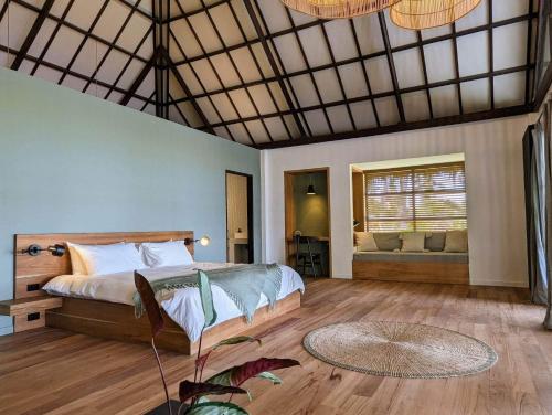 a bedroom with a bed and a couch in a room at Kalinaw Resort in General Luna