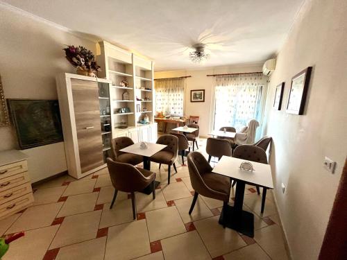 ein Restaurant mit Tischen und Stühlen in einem Zimmer in der Unterkunft Rooms Dionis in Tirana