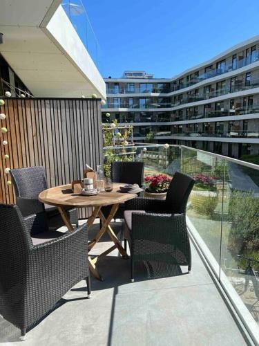 a patio with a table and chairs on a balcony at Bo med stil og udsigt til Aarhus lystbådehavn in Aarhus