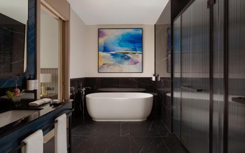 a bathroom with a bath tub and a sink at InterContinental Tashkent by IHG in Tashkent