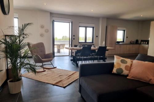 un salon avec un canapé et une table avec des chaises dans l'établissement Saint Remy de Provence Roof top avec jacuzzi, à Saint-Rémy-de-Provence