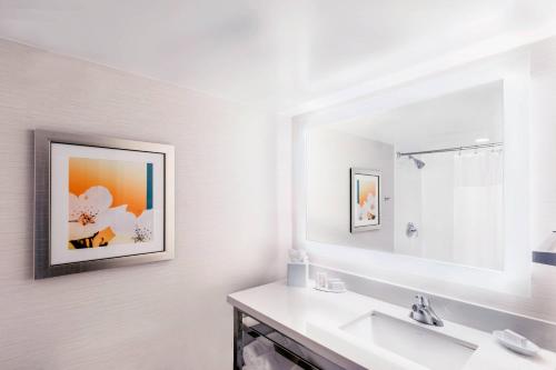 a white bathroom with a sink and a mirror at Fairfield Inn & Suites by Marriott Charlotte Uptown in Charlotte