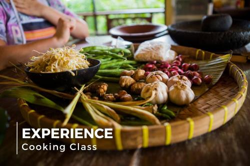 a tray filled with vegetables on a wooden table at La Charm Hoi An Hotel & Spa in Hoi An