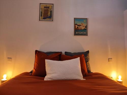 um quarto com uma cama com almofadas laranja em Lo Mas dei Santés em Bédarrides