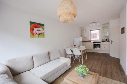 a white living room with a couch and a table at Wohnen am Park in Lübeck