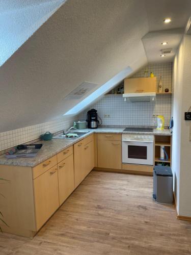 an attic kitchen with a sink and a stove at Ferienwohnung Klitzschen Nähe Torgau in Mockrehna