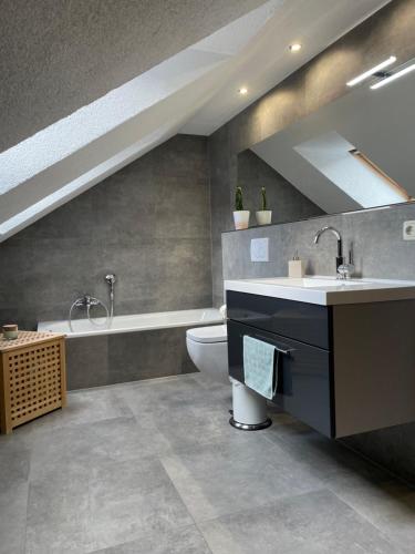 een badkamer met een wastafel, een toilet en een bad bij Ferienwohnung Klitzschen Nähe Torgau in Mockrehna
