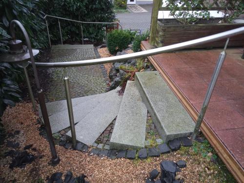 a garden with a metal railing and some rocks at Ferienwohnung Bermbach in Weilburg