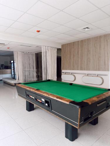 a pool table in a room with a green at Seaview apartments in Ayios Elias