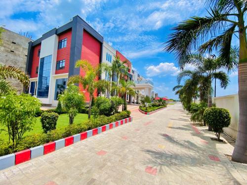 a street in front of a building with palm trees at Mauryan's Premier in Gaya
