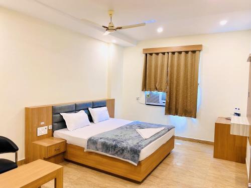 a small bedroom with a bed and a window at Mauryan's Premier in Gaya