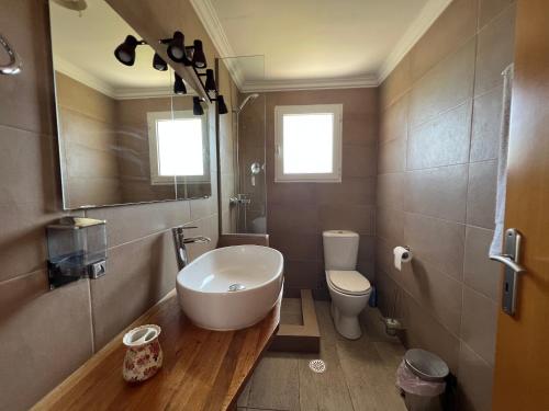 ein Bad mit einem Waschbecken und einem WC in der Unterkunft Reginas Apartments in Ixia