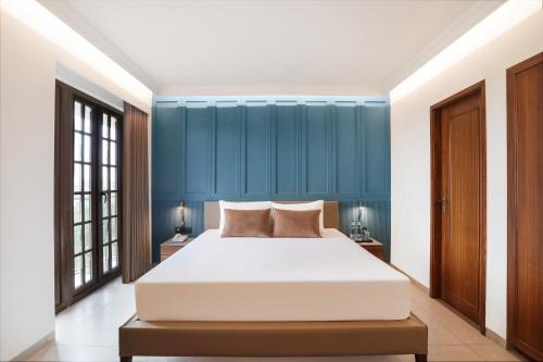 a bedroom with a large bed and blue walls at Lemon Tree Hotel, Rajkot in Rajkot