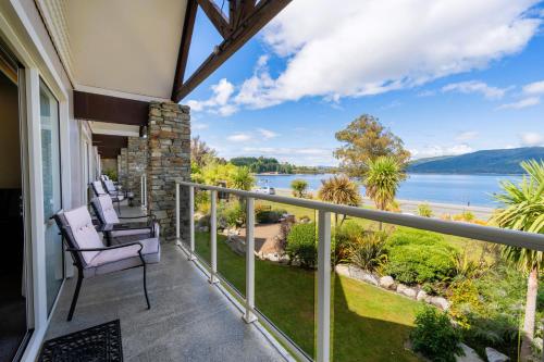 a balcony with chairs and a view of the water at Fiordland Lakeview Motel and Apartments in Te Anau