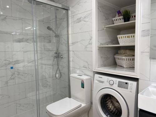 een badkamer met een wasmachine en een douche bij Sea View Apartment en Mogán in Playa del Cura