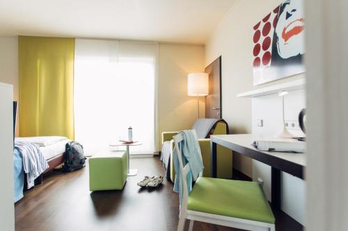 a room with a bedroom with a bed and a desk at harry's home hotel & apartments in Graz