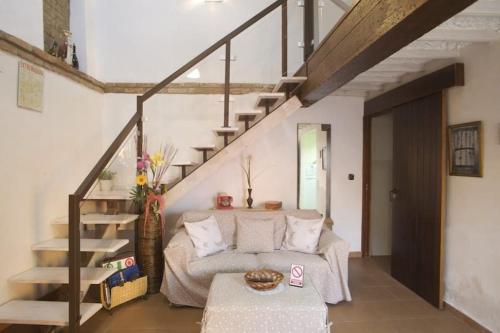 a living room with a couch and a staircase at La Casina de Carcaboso in Carcaboso