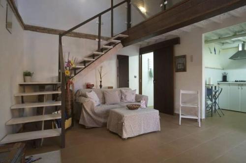 a living room with a couch and a stair case at La Casina de Carcaboso in Carcaboso