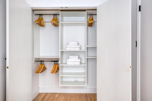 a walk in closet with white cabinets and orange umbrellas at Soho 3br w wd elevator nr cafes restaurants NYC-1043 in New York