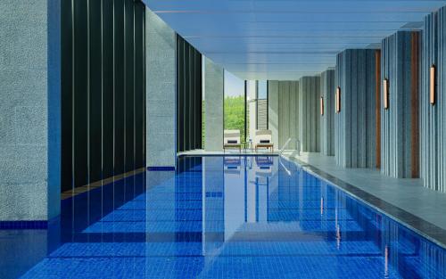 a swimming pool in a building with blue tiles at InterContinental Tashkent, an IHG Hotel in Tashkent