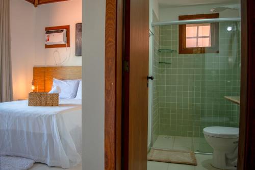 a bathroom with a bed and a shower with a toilet at Meu Paraíso em Búzios in Búzios