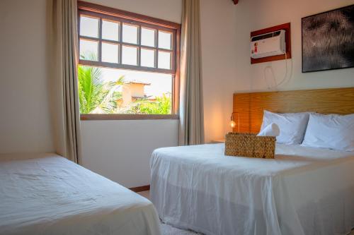 a hotel room with two beds and a window at Meu Paraíso em Búzios - 70 metros da Praia in Búzios