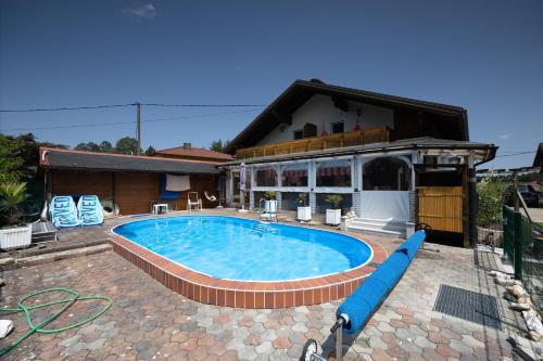 a large swimming pool in front of a house at Christis Apartments in Eberndorf