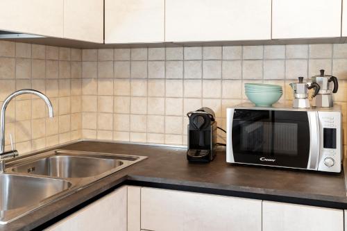 encimera de cocina con microondas y fregadero en HelloChalet - Le Fleury Family Apartment 600mt cablecar, en Valtournenche
