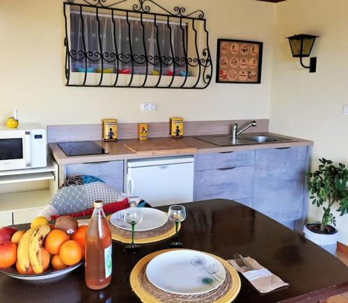 - une cuisine avec une table et un bol de fruits dans l'établissement Au Piémont des Vosges, à Gertwiller