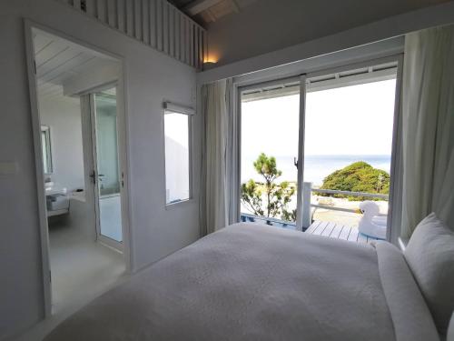 a bedroom with a large bed and a view of the ocean at Ample Villa 小希臘民宿 in Ruifang