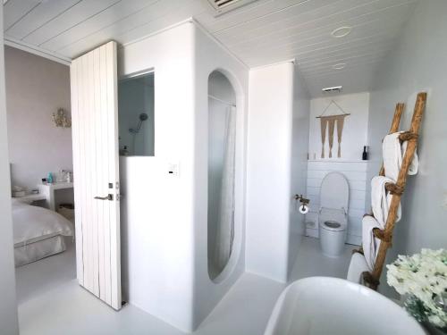 a white bathroom with a toilet and a sink at Ample Villa 小希臘民宿 in Ruifang