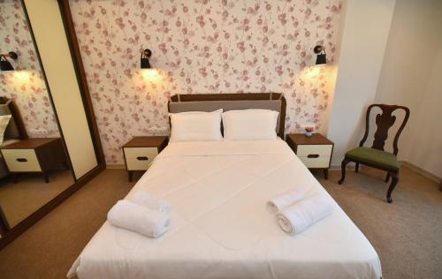 a bedroom with a bed with two towels on it at Hotel Avenue 30 in Yerevan